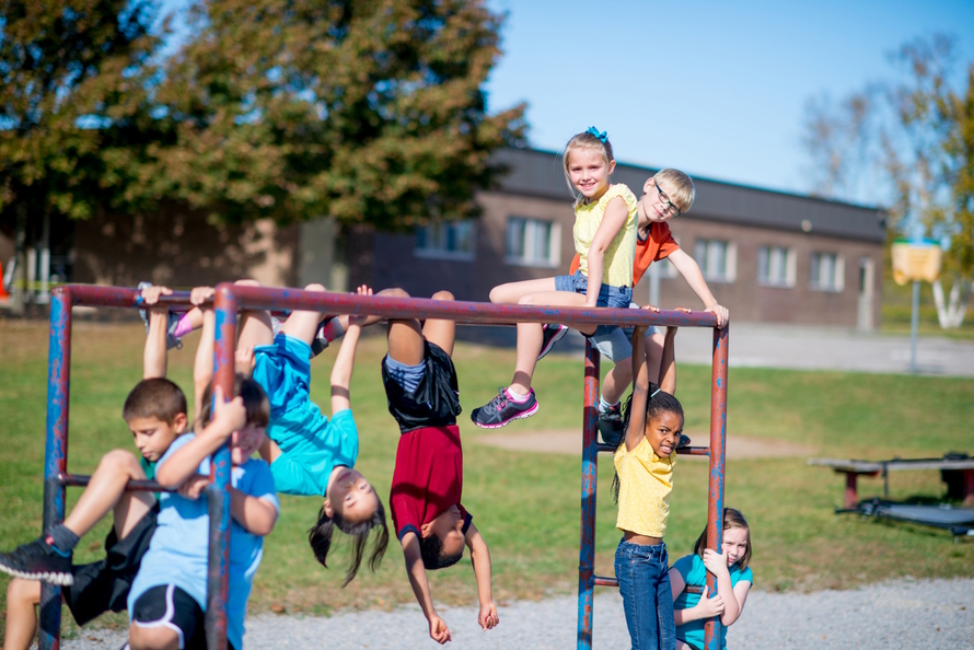 Group of children playing on a climbing structure at school
