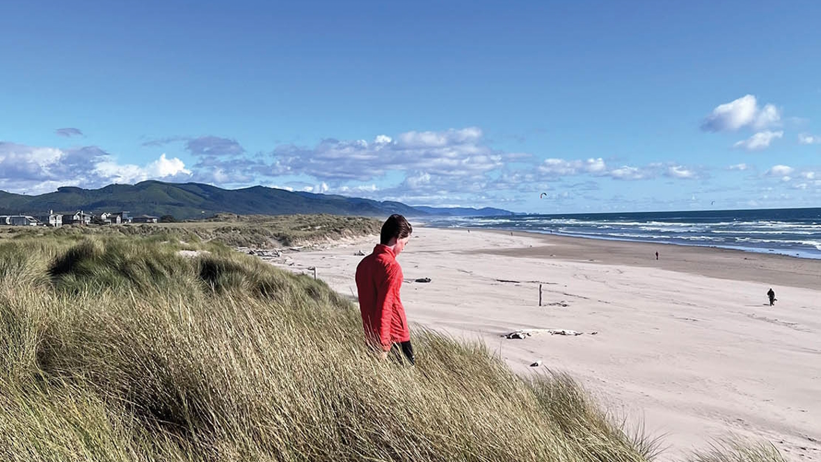 Person standing on the beach on a sunny day in Manzanita, Oregon