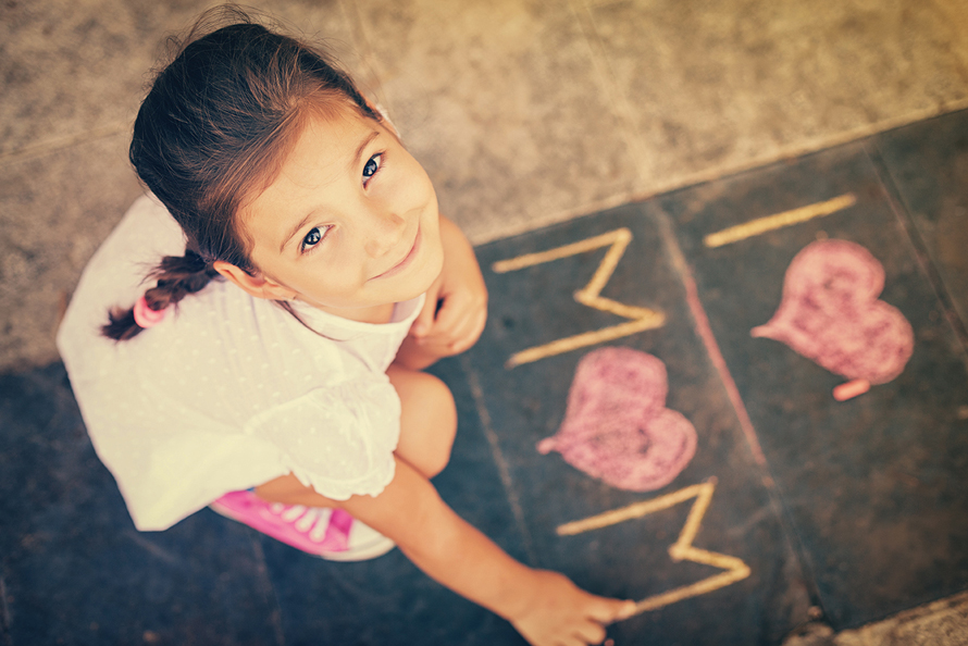 girl writing in chalk I love mom