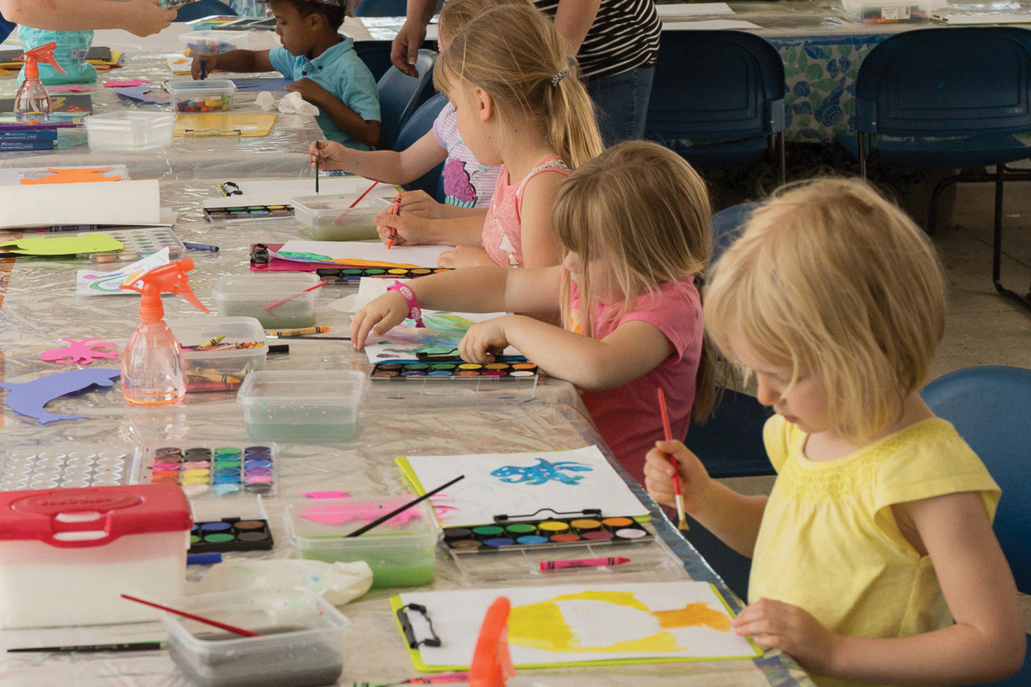 Young girls sitting at a table painting pictures