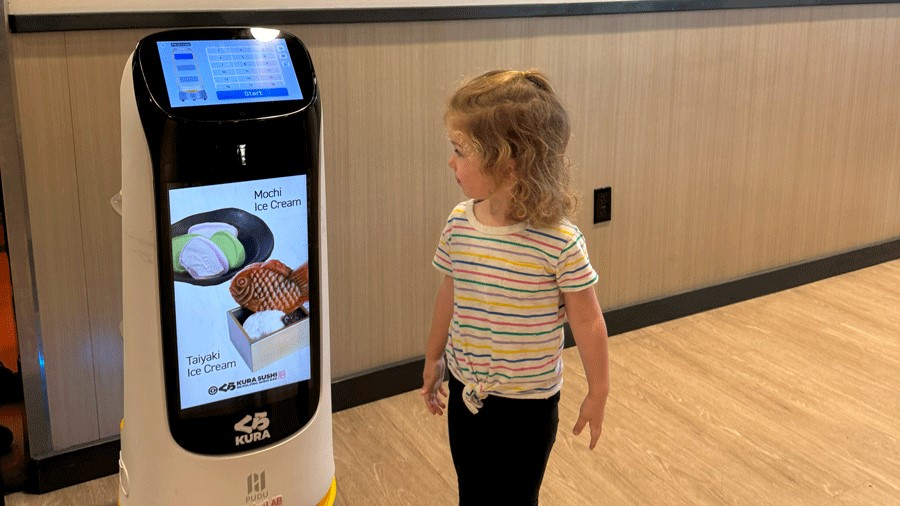 Young girl looking at the robot at Kura Sushi, a sushi conveyor belt restaurant in Bellevue