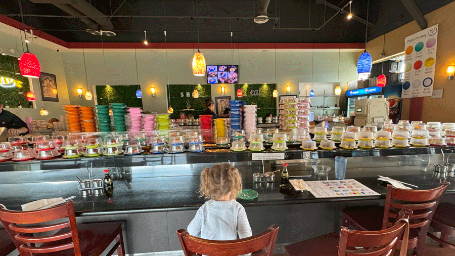 Stacks of sushi plates rotating on a conveyor belt at Belt Sushi & Roll in Marysville, a Seattle-area sushi restaurant
