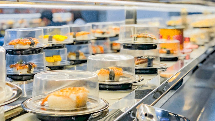 plates of sushi rotating on a sushi conveyor belt at a restaurant near Seattle