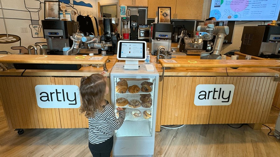 Young girl orders from a touch screen table at Artly Coffee, a Seattle robot restaurant with espresso drinks