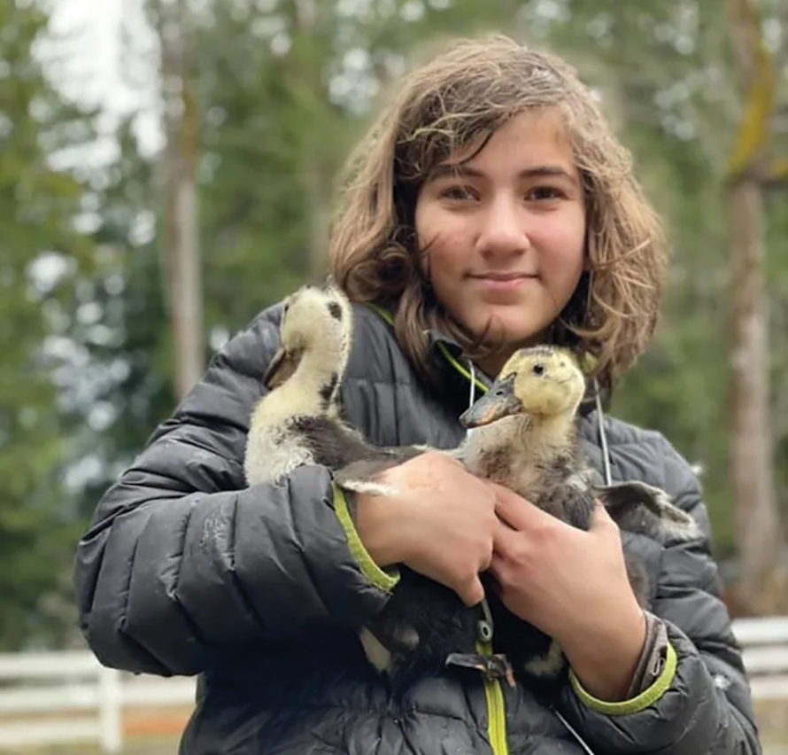 Gril holding two ducks