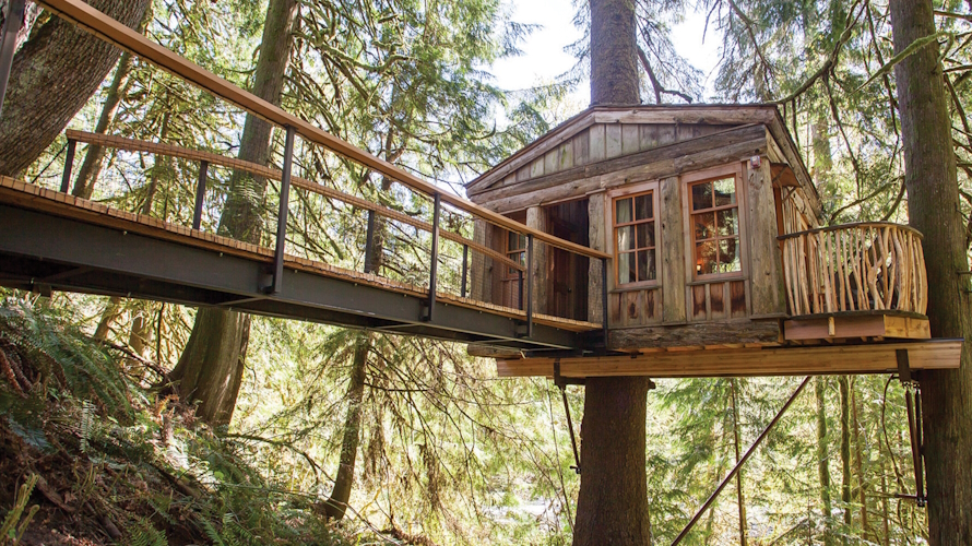 A treehouse with a long bridge leading away at TreeHouse Point