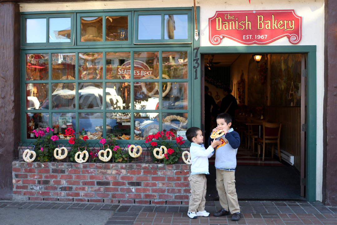 boys hold a giant pretzel in front of the Danish Bakery in Leavenworth Washington perfect fall getaway for Seattle area families
