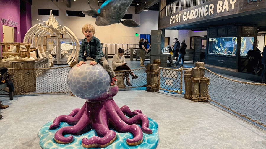 Toddler playing on an octopus statue at Imagine Children’s Museum in Everett