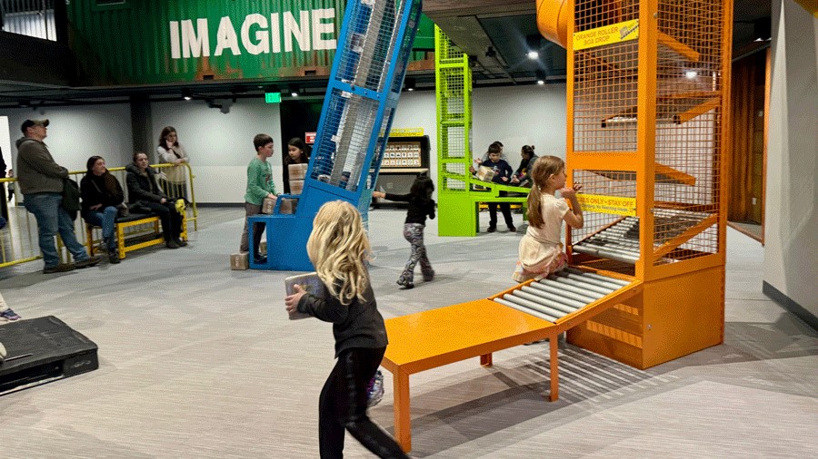 Young kids playing at the distribution center exhibit at  Imagine Children’s Museum in Everett