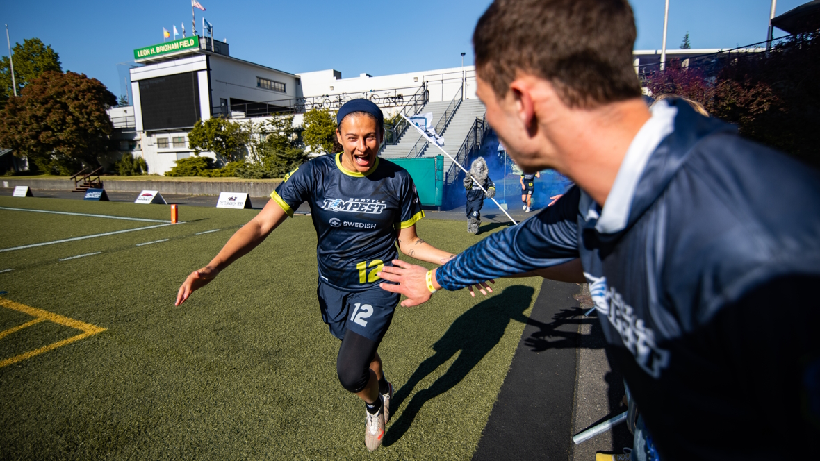 Seattle Ultimate Frisbee player on the Tempest team gives high fives to the crowd