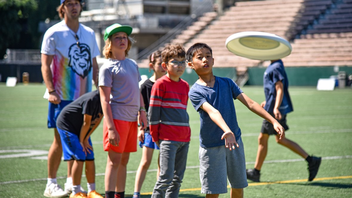 Kids lean the basics of Seattle Ultimate Frisbee at a pre-game clinic