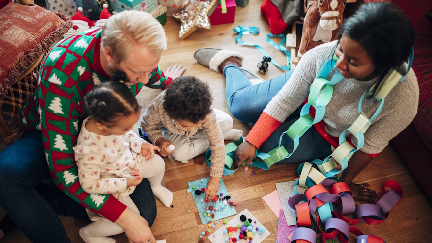 Family sitting on the floor doing holiday crafts