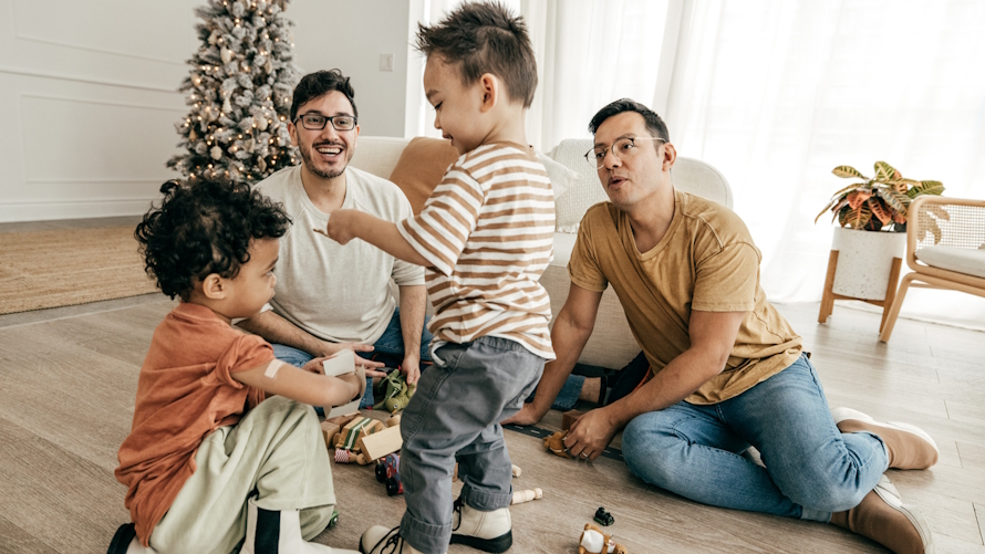 Family in the living room with Christmas tree behind them