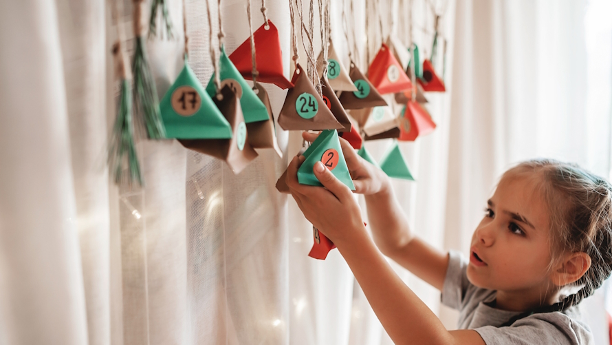 Girl standing next to a home made advent calendar