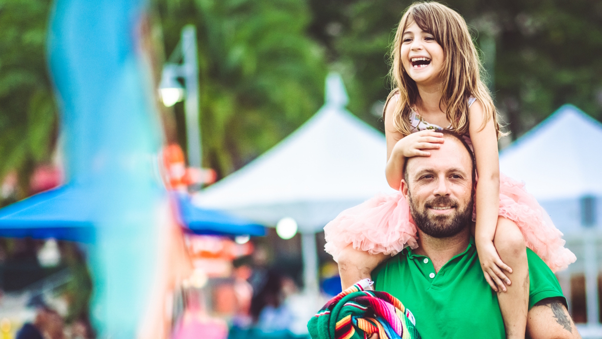 dad with daughter on shoulders at a spring family festival