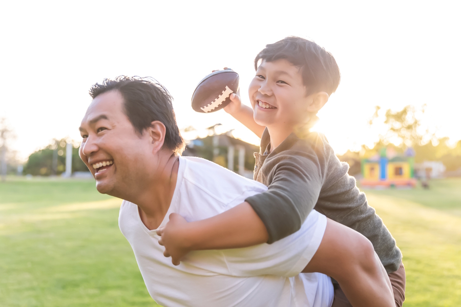 dad and son playing football together and having fun