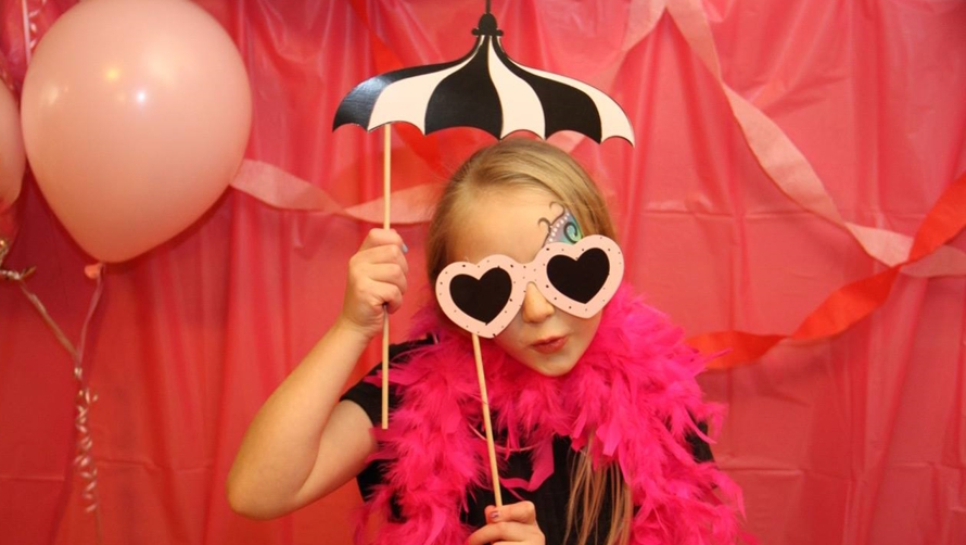 Young girl posing with props for a photo booth