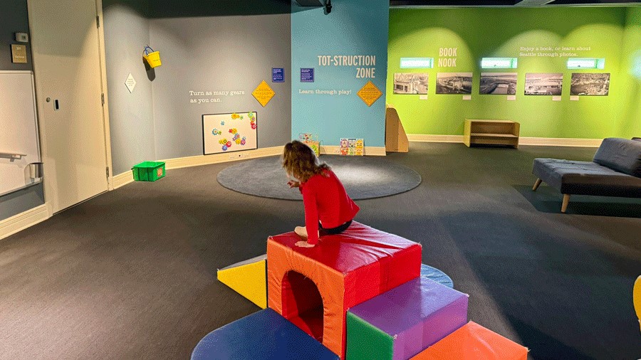 Young girl playing on play couch with tunnel in MOHAI’s Kid-Struction Zone