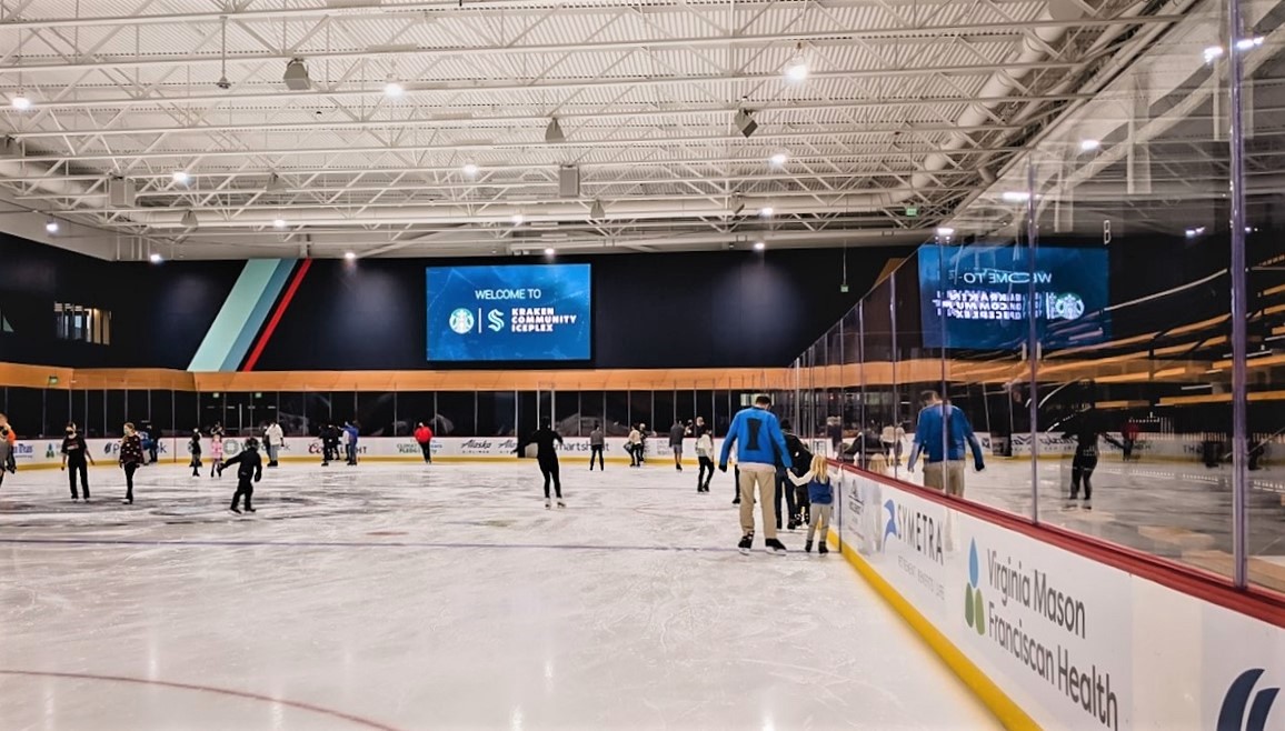 Father and daughter skate hand-in-hand at the new Kraken Community Iceplex in Seattle