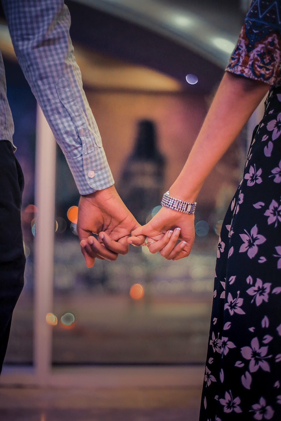 Couple holding hands with linked pinky fingers