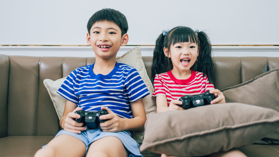 Boy and girl on the couch playing video games how to raise a healthy gamer