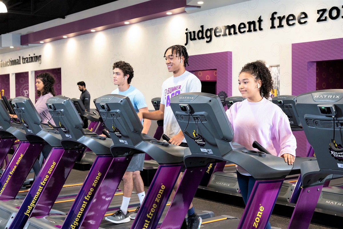 High schoolers working out on treadmills at Planet Fitness locations offering free workouts to teens summer 2022