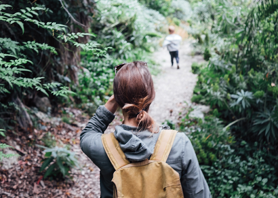 woman on a hiking trail with her kid running ahead