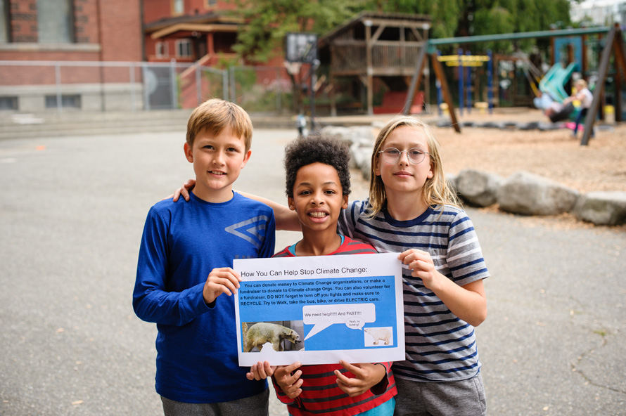 3 giddens students holding a climate change poster