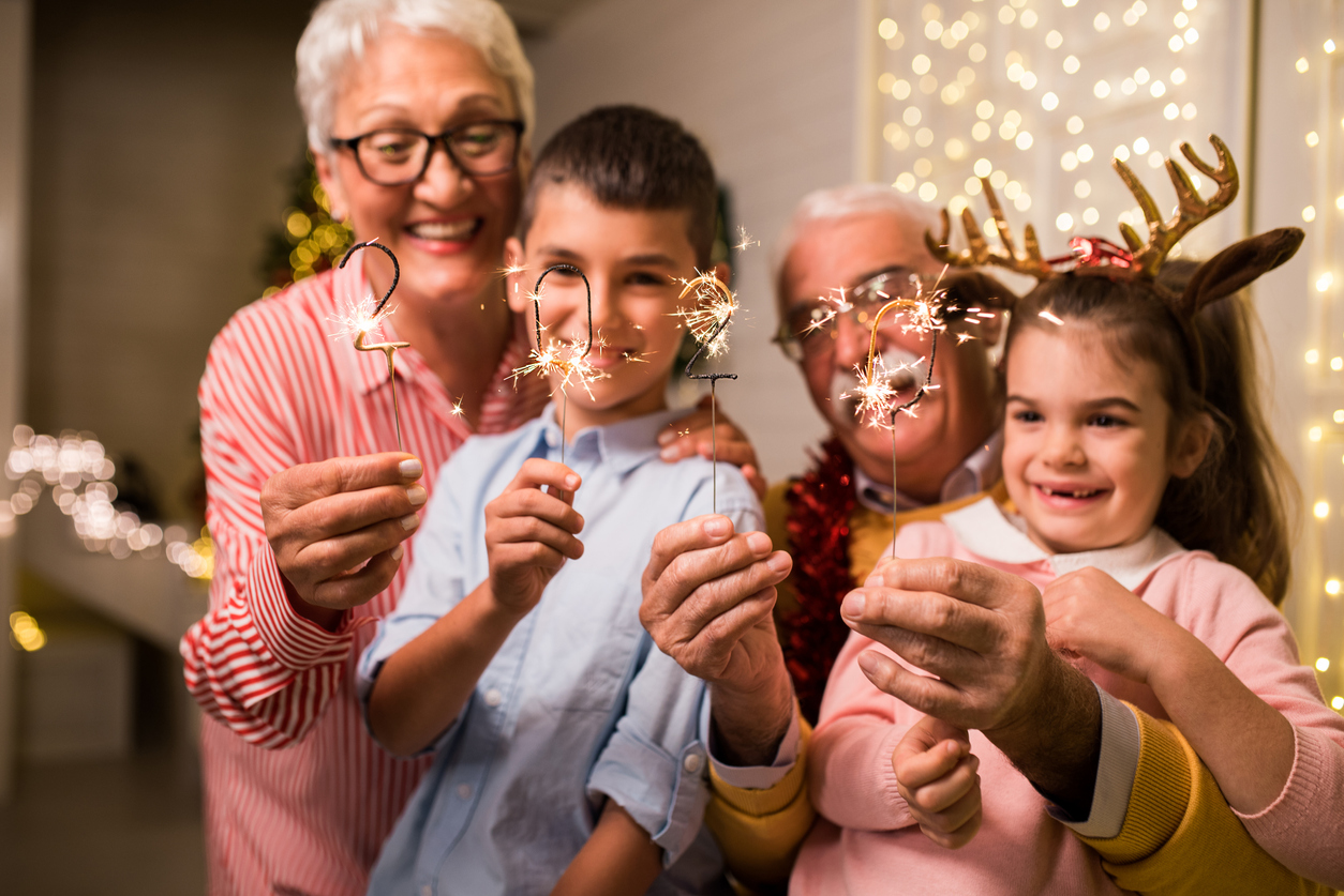 grandparents with grandchildren holding new year sparklers