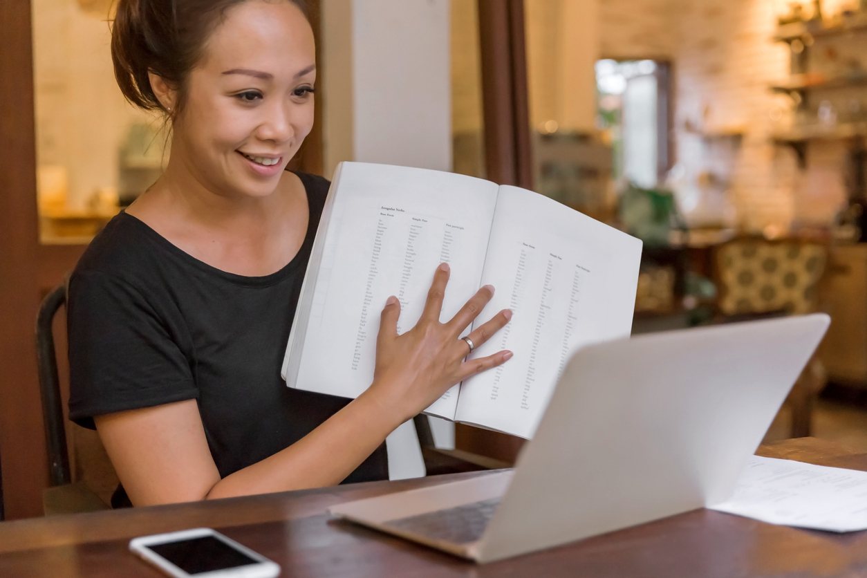 woman teaching in front of her laptop smiling