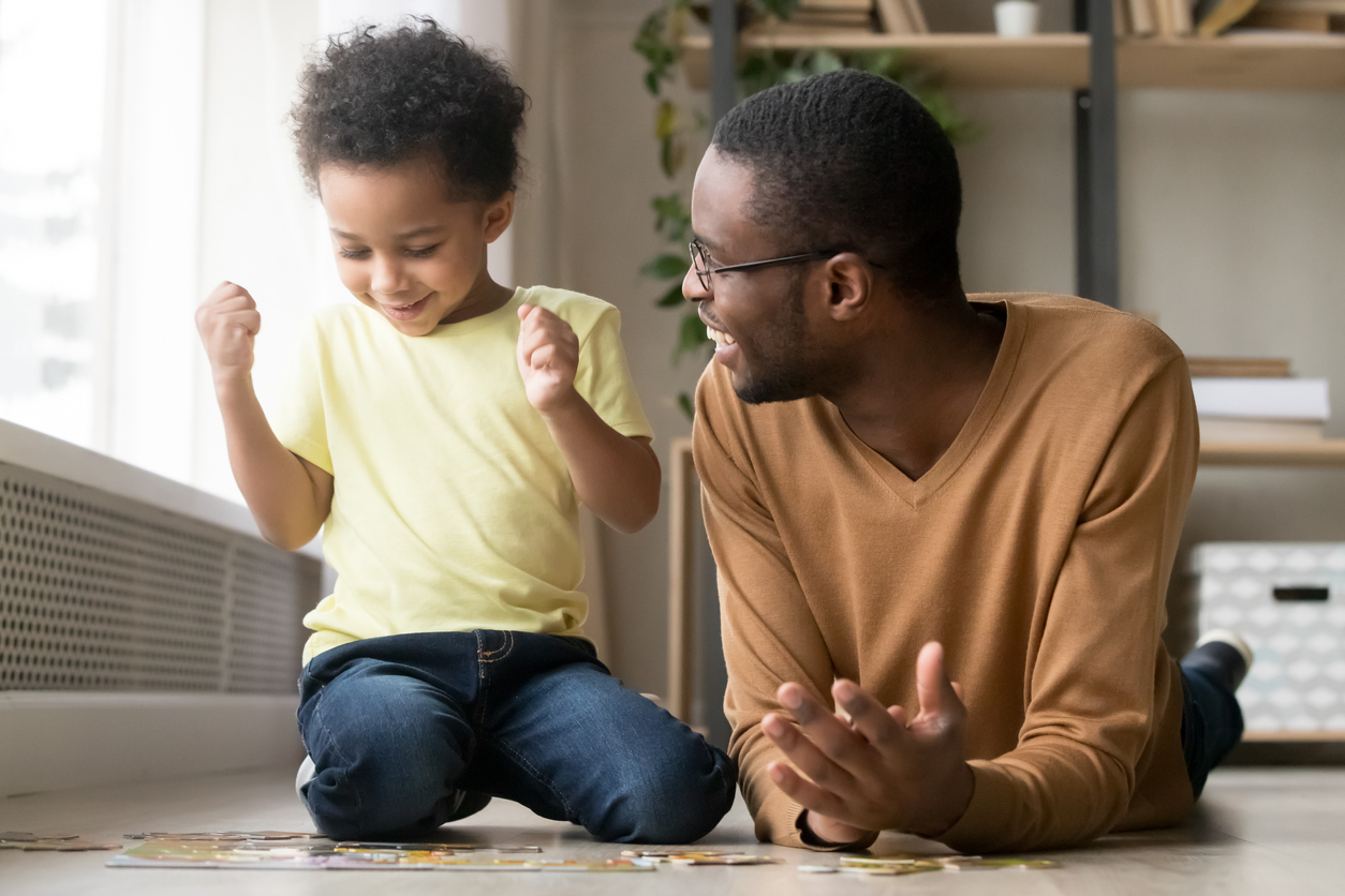 father and son doing a puzzle on the floor