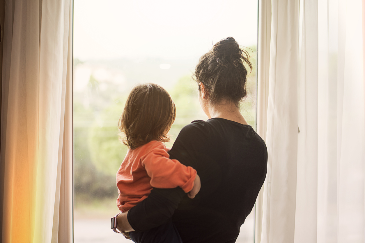 mother holding her son looking out the window