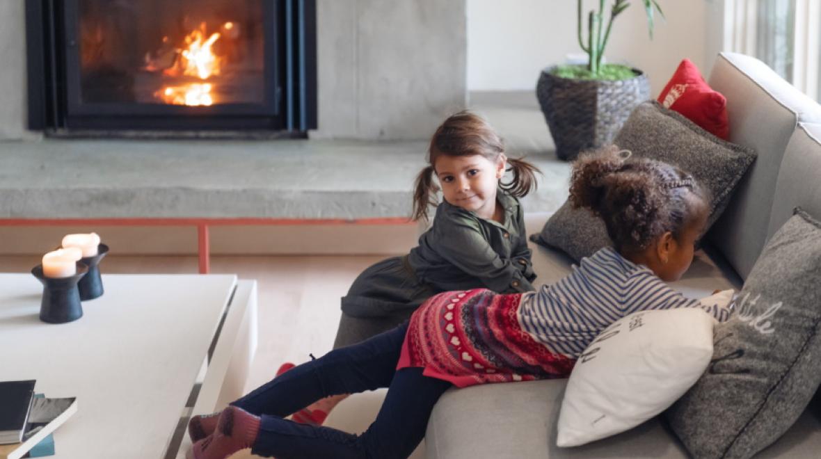 two girls leaning against a couch with festive pillows