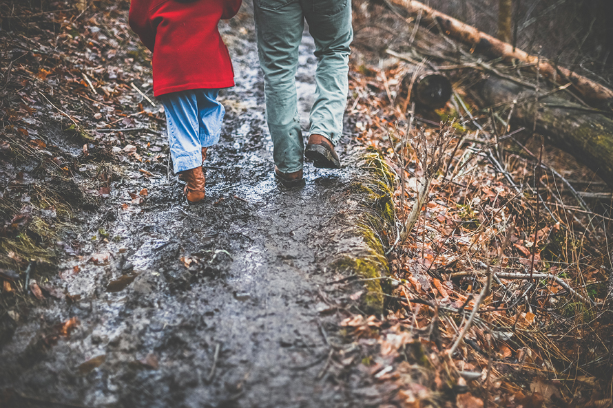 muddy path with two people's legs walking