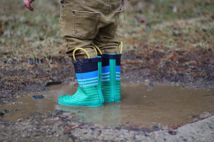 kid boots standing in a mud puddle