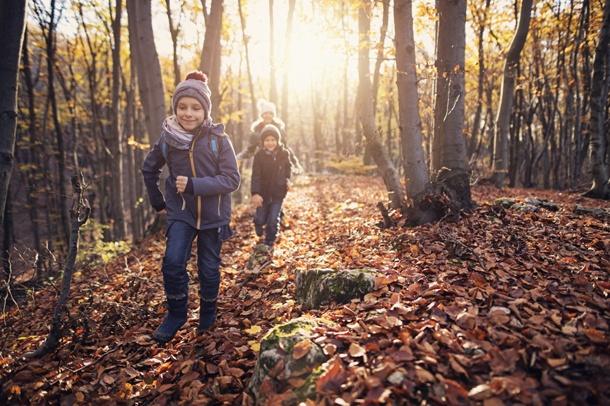 bundled up kids walking through the woods