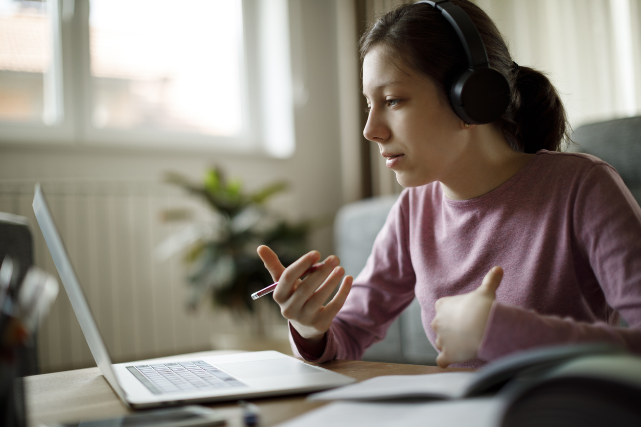 Teen girl doing her schoolwork remotely