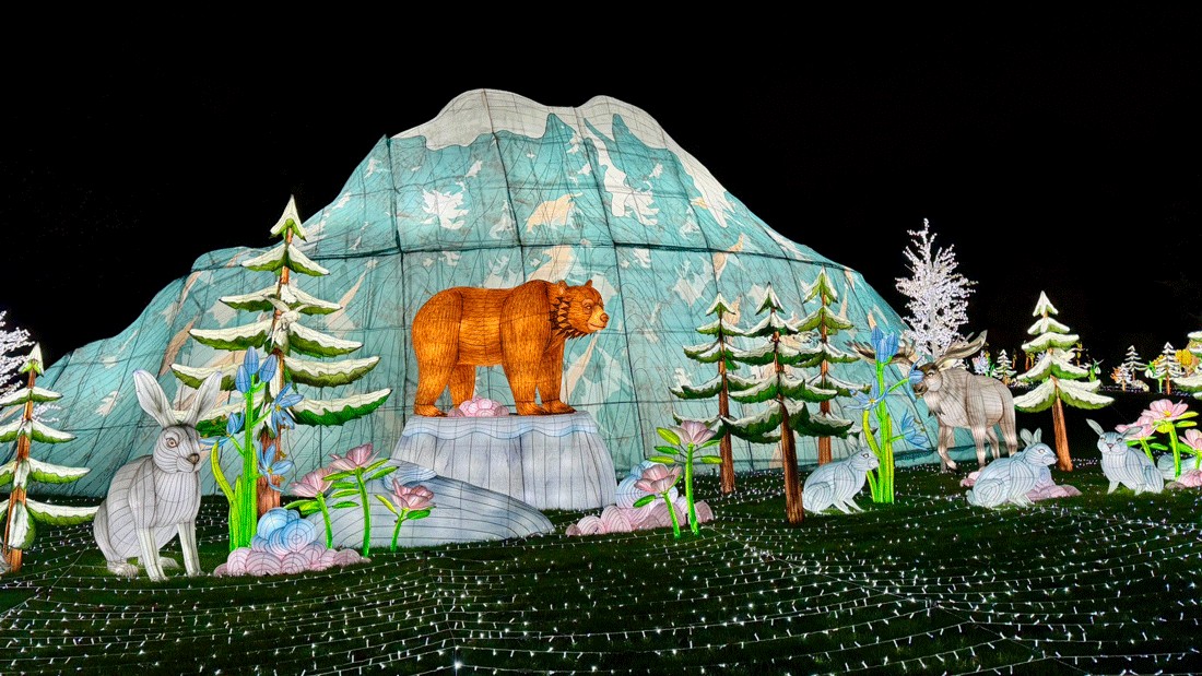 holiday light display at Woodland Park Zoo's WildLanterns with a mountain and snowy animal-filled scene