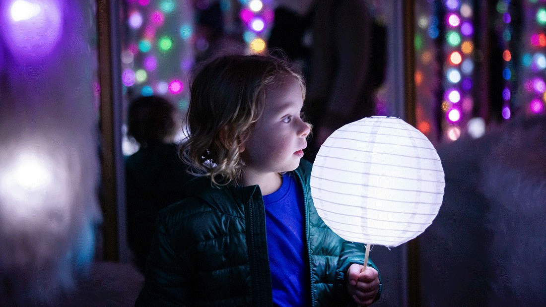 child holding a lantern on the Tacoma Light Trail, a holiday light experience