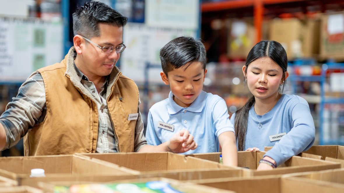 family volunteering and putting food into boxes at a food distribution center