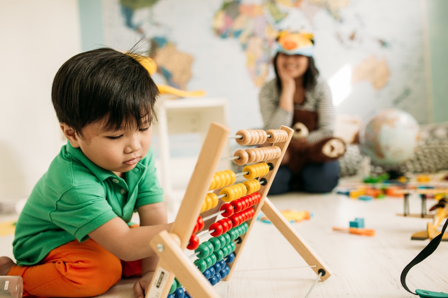 young boy playing with an abacus