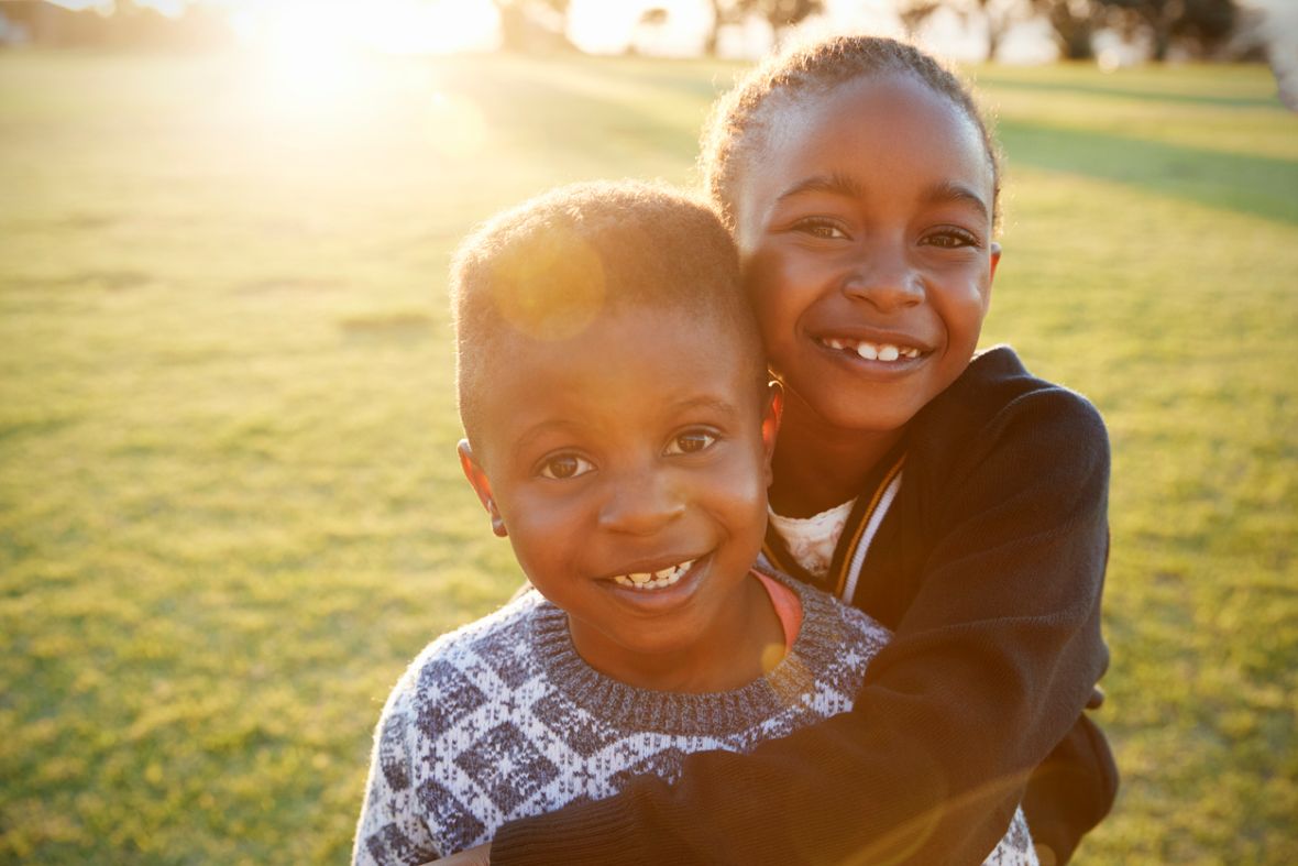 Black History Month events with smiling African American boy and girl hugging each other.