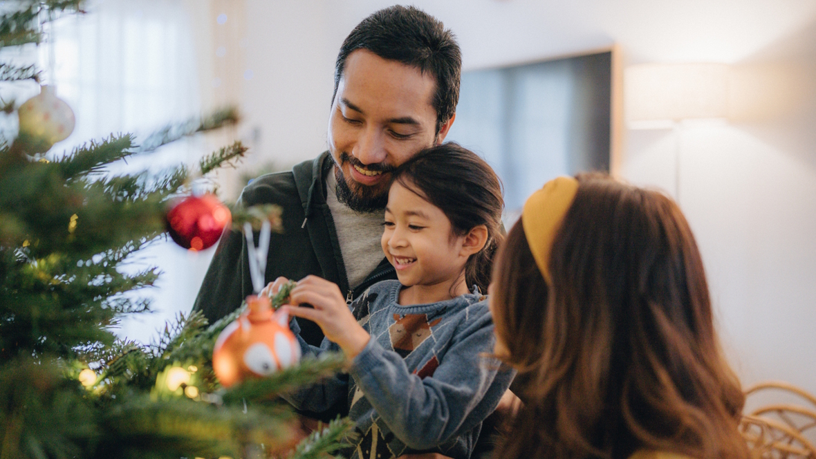 family decorating a Christmas tree