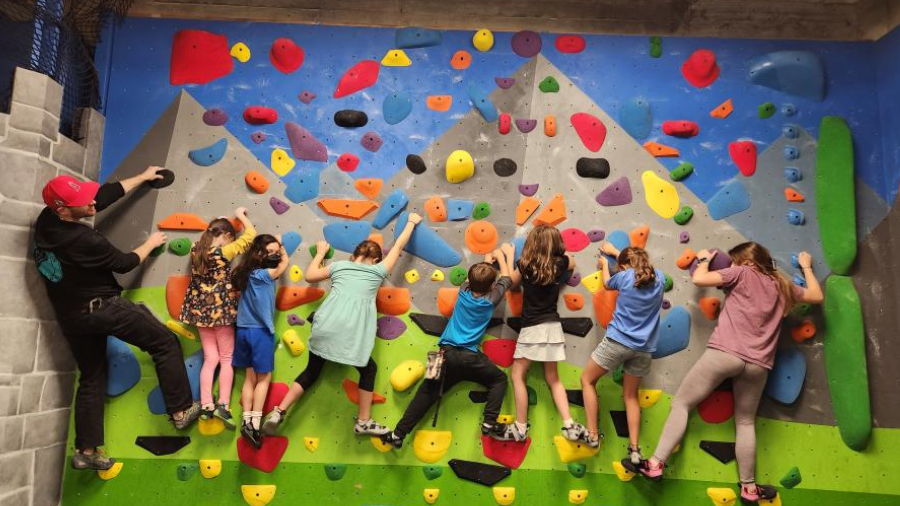 group of kids and people climbing a wall