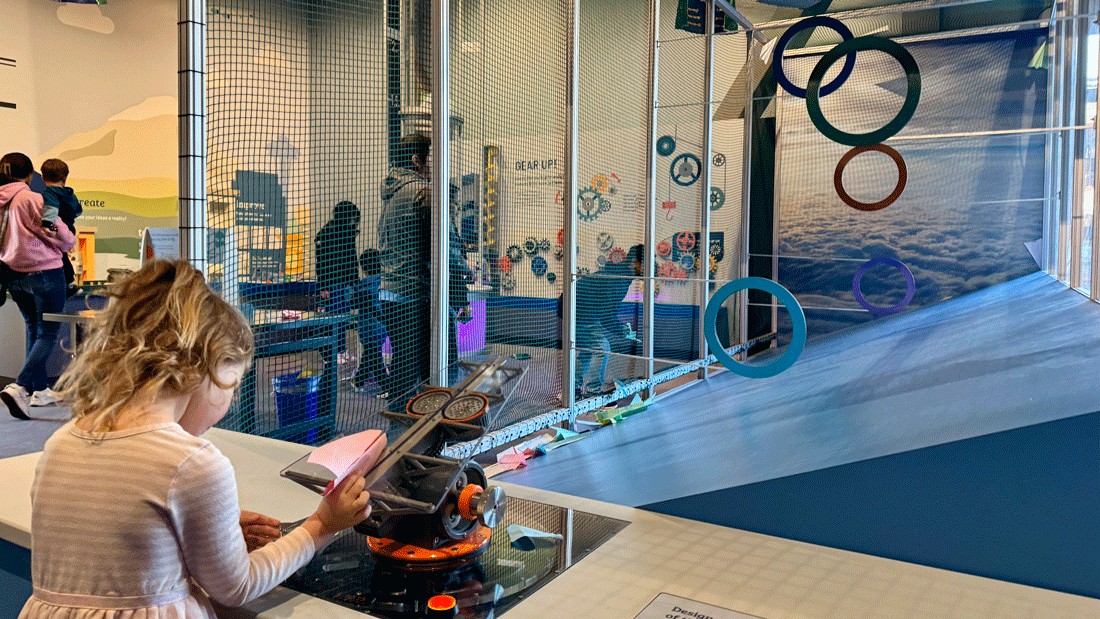Child testing out paper airplane designs with the new interactive launcher at Imagine Children's Museum
