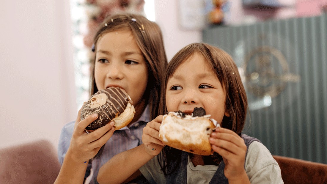 kids eating doughnuts on a walking food tour in Seattle