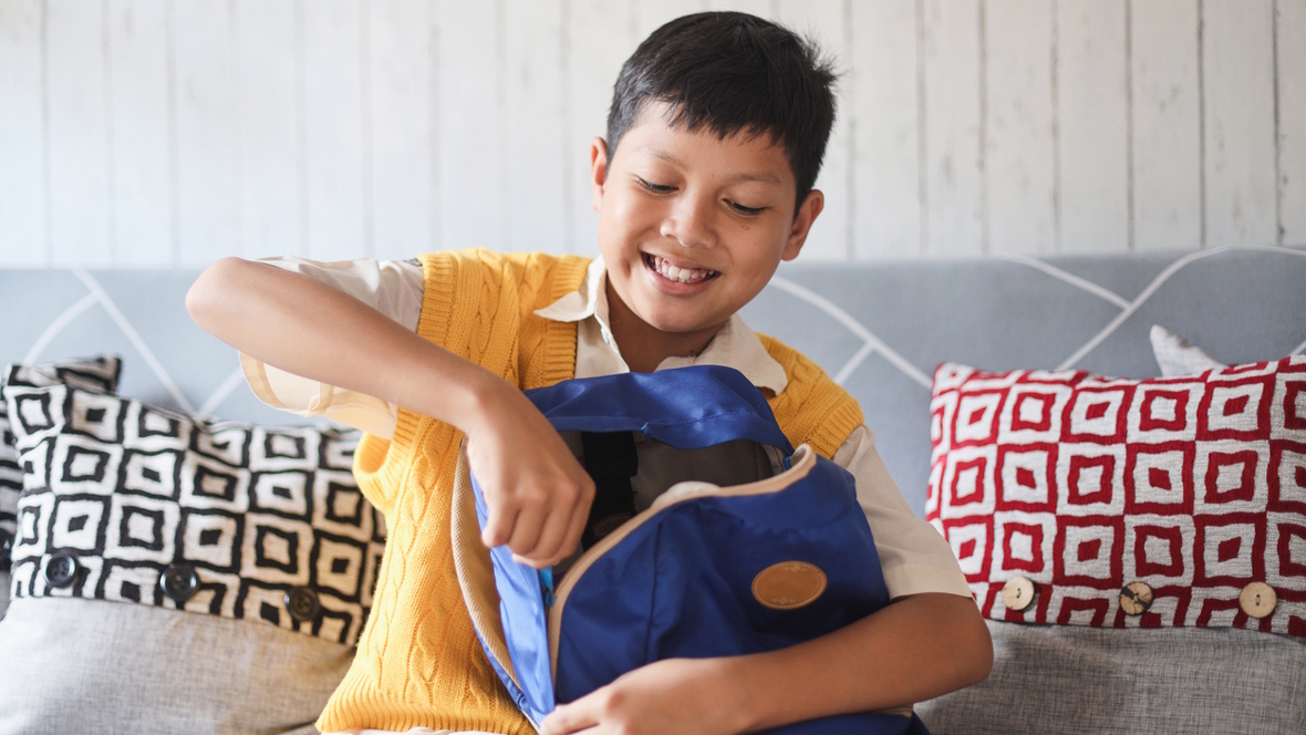 boy packing his backpack before school