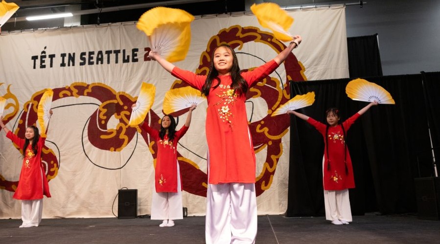 Dancers with yellow fans at Tet in Seattle at Seattle Center.