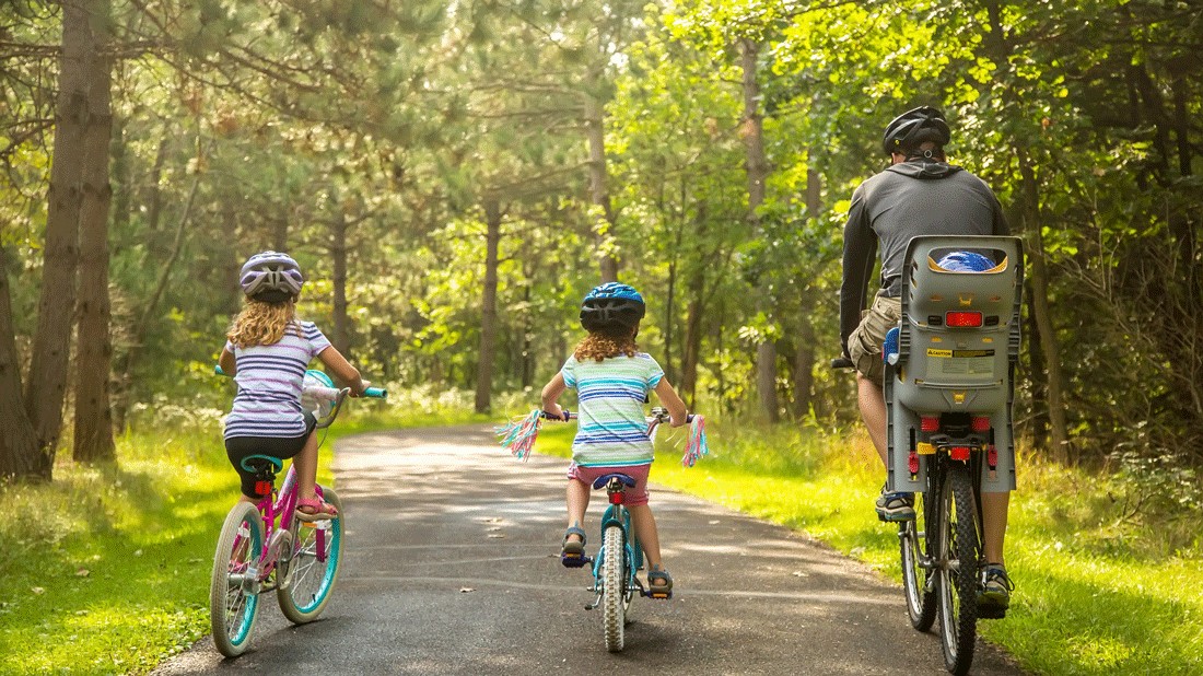 father with children riding a paved bike path near Puyallup