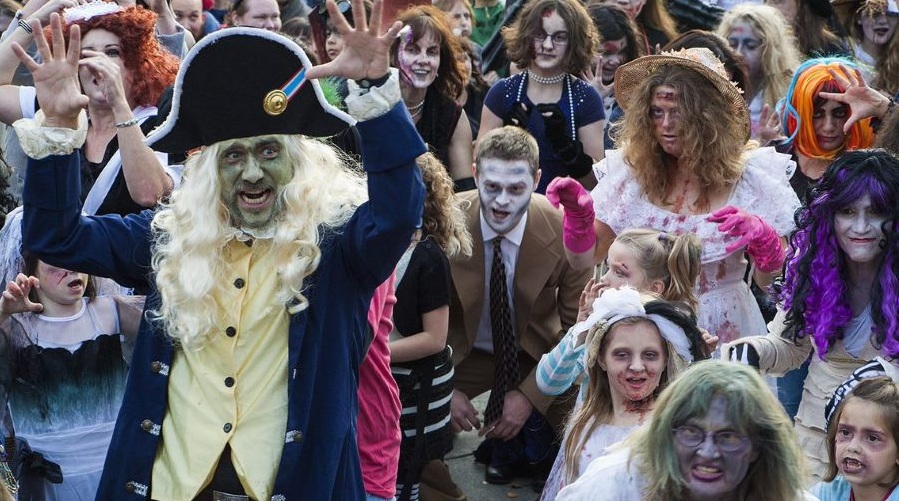 Participants of all ages in zombie make up and garb for a Zombie Walk.